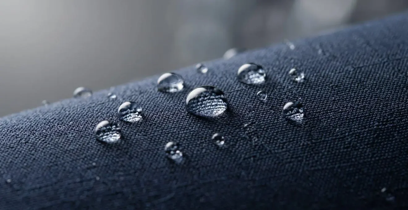 Gros plan sur un blazer technique déperlant avec des gouttes d'eau perlant sur le tissu