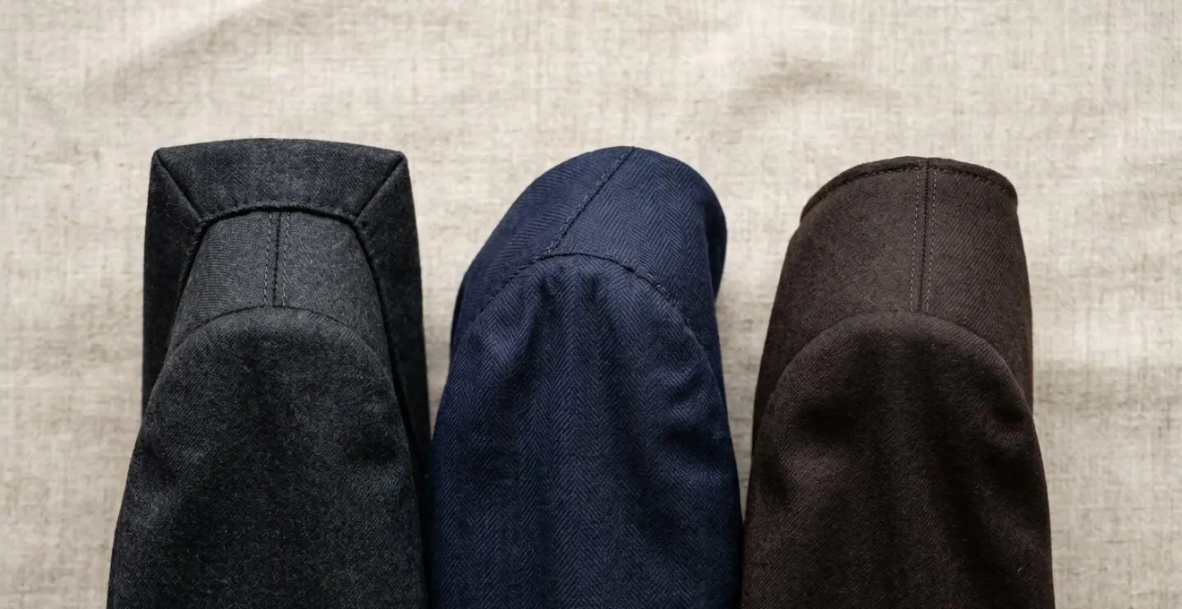 Comparaison visuelle entre trois styles d'épaules de veste : anglaise structurée, napolitaine souple et cigarette parisienne