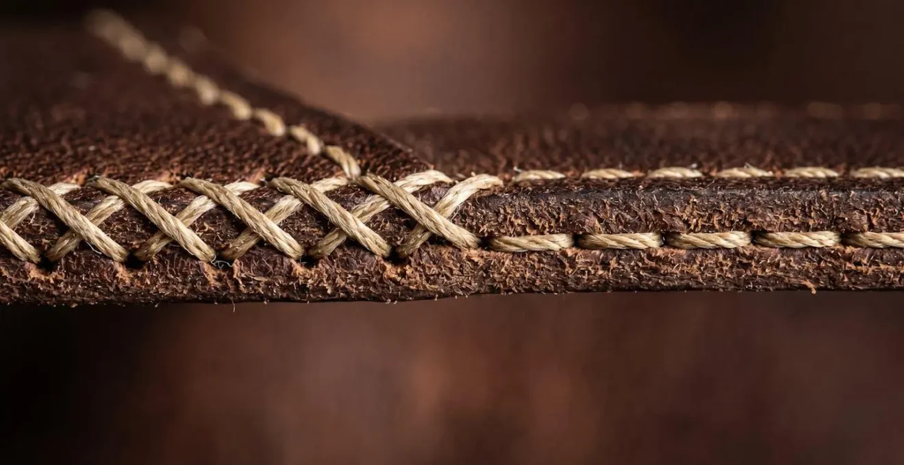 Vue détaillée d'une couture point sellier montrant l'asymétrie caractéristique entre recto et verso