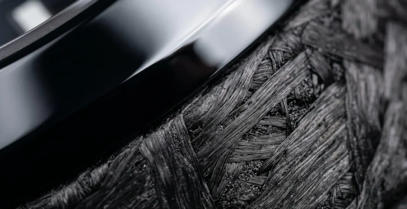 Macro détaillée montrant les textures de céramique noire et carbone forgé sur boîtiers de montres